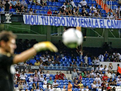 Casillas, suplente anoche, calienta antes del partido ante una pancarta de apoyo a Mourinho colgada en el primer anfiteatro.
