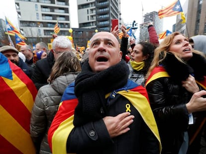 Un manifestante canta el himno catalán con la mano en el corazón.