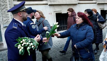 Una mujer recibe un tulipán de un oficial de policía durante el Día Internacional de la Mujer, este viernes en Bucarest (Rumania).