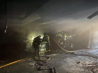 Los bomberos sofocan el incendio de dos coches eléctricos en el parking de Marqués de Urquijo, el 8 de febrero.