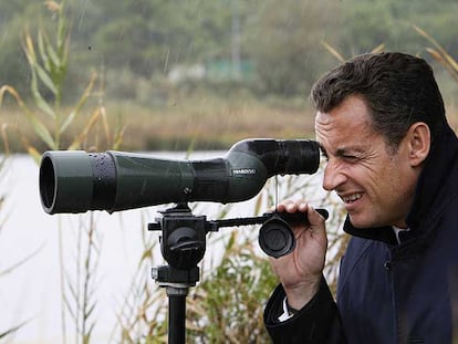 Nicolas Sarkozy observa a través de un catalejo en su visita de ayer a una reserva de aves en Biguglia, Córcega.