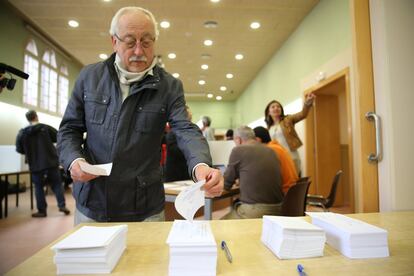 Un votant davant la taula de les paperetes del centre de votació obert a l'IES Juan Manuel Zafra de Barcelona.