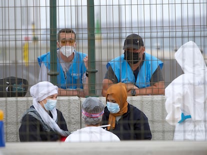 Agentes de Frontex observan a dos migrantes en Puerto del Rosario (Fuerteventura) el 28 de mayo.