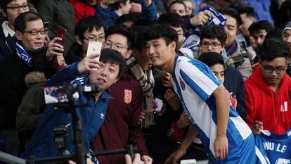 Wu Lei, del Espanyol, posa con aficionados en Barcelona.  