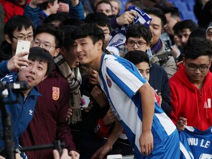 Wu Lei, del Espanyol, posa con aficionados en Barcelona.  