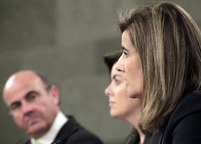 La vicepresidenta del Gobierno, Soraya Sáenz de Santamaría (c); la ministra de Empleo, Fátima Báñez, y el ministro de Economía, Luis de Guindos, durante la rueda de prensa posterior al Consejo de Ministros.