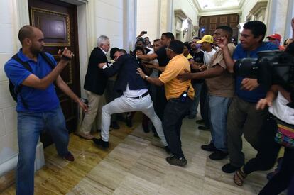 Un opositor forcejea con simpatizantes del Gobierno en Venezuela, luego de que éstos irrumpieran en la Asamblea Nacional para reventar la sesión en la que se discutiría un juicio político contra Nicolás Maduro.