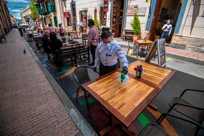 Una mujer limpia una mesa en un restaurante de Bogotá, el pasado 16 de octubre.