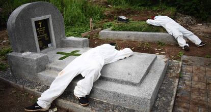 Dos sepultureros exhaustos descansan entre las tumbas de un cementerio destinado a víctimas del Covid-19 en Bandung, Indonesia.