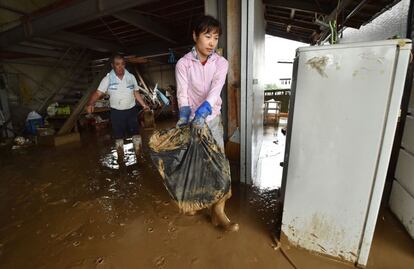 Las inundaciones y crecidas de ríos se han llevado por delante viviendas enteras, tramos de carreteras locales, vehículos, vías de tren e incluso puentes. En la foto, residentes retiran el barro de sus casas, el 6 de julio de 2017 en Asakura.