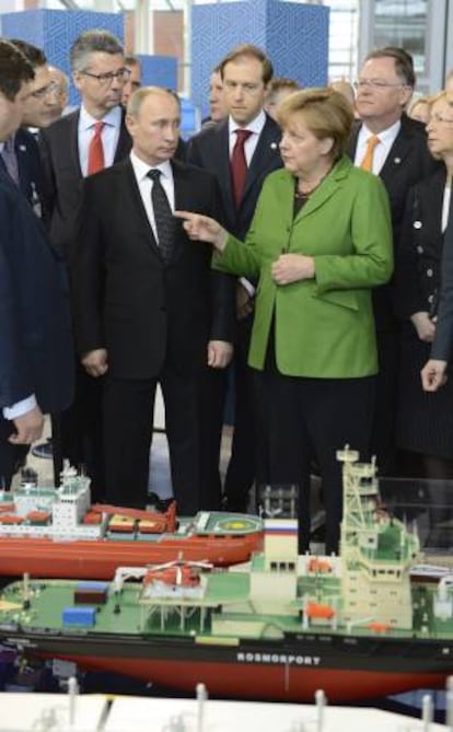 La canciller alemana, Angela Merkel, y el presidente ruso, Vladimir Putin (2-i), visitan el expositor de Rusia durante su visita a la Feria de Hanover, en Alemania.