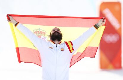 El deportista español sujeta la bandera de España antes de recibir la medalla de bronce en el podio.