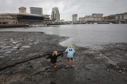 Dos niñas caminan por la orilla de la bahía de Tampa. En esta zona, el nivel de las aguas ha bajado porque el viento y la marea las empuja. Al situarse al norte del ojo del huracán, los vientos van desde tierra hacia el mar, pues el huracán se mueve en sentido contrario a las agujas del reloj. 