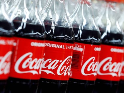 Un lineal de supermercado con botellas de Coca-Cola.