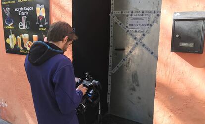 Un cámara de Telemadrid graba la puerta de La Tetería, precintada por la Policía Nacional.