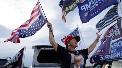 Una seguidora de Trump lleva la bandera estadounidense de cabeza, este jueves cerca de la residencia del expresidente en Palm Beach (Florida).