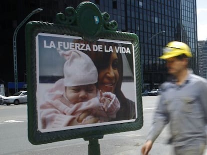 Un obrero camina frente a un cartel electoral.