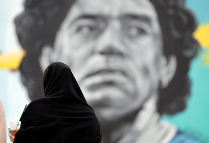 Una mujer catarí observa un mural del exjugador argentino Diego Armando Maradona, en frente del estadio Al Khalifa de Doha, Qatar, este viernes.