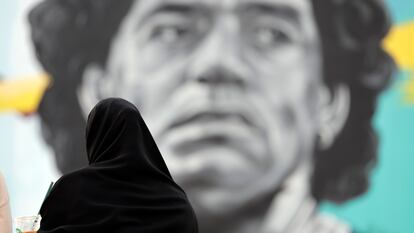 Una mujer catarí observa un mural del exjugador argentino Diego Armando Maradona, en frente del estadio Al Khalifa de Doha, Qatar, este viernes.