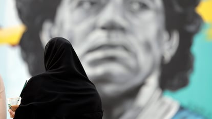 Una mujer catarí observa un mural del exjugador argentino Diego Armando Maradona, en frente del estadio Al Khalifa de Doha, Qatar, este viernes.