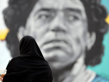 Una mujer catarí observa un mural del exjugador argentino Diego Armando Maradona, en frente del estadio Al Khalifa de Doha, Qatar, este viernes.