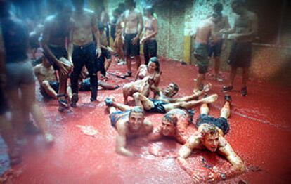 Un grupo de jóvenes se zambullen en el caldo de tomate tras la <b><i>batalla</b></i>, ayer en Buñol.