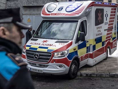 Un agente de la Policía Local y una ambulancia, el viernes ante el portal donde residían las dos menores en el barrio de La Ería, en Oviedo.