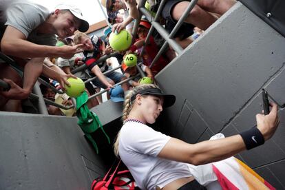 La tenista canadiense Eugenie Bouchard se hace selfis con los aficionados tras ganar a la china Shuai Peng durante un partido de tenis del Abierto de Australia 2019, disputado en Melbourne.
