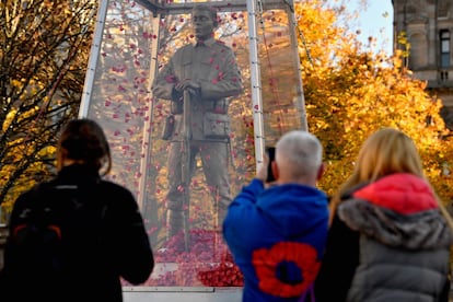 Varias personas fotografían la estátua 'Every Man Remembered', en Glasgow (Escocia).