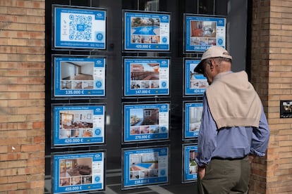 Un hombre observa el escaparate de una inmobiliaria de venta y alquiler de pisos en Sevilla.