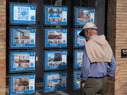 Un hombre observa el escaparate de una inmobiliaria de venta y alquiler de pisos en Sevilla.