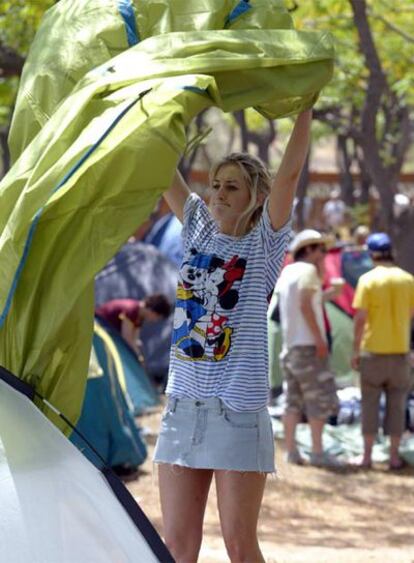 Una joven monta su tienda de campaña en el camping del festival de Benicassim.