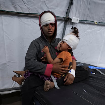 SENSITIVE MATERIAL. THIS IMAGE MAY OFFEND OR DISTURB A wounded Palestinian sits while holding a child, at Al-Ahli Arab Baptist hospital, following an Israeli strike, in Gaza City, May 26, 2025. REUTERS/Dawoud Abu Alkas