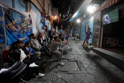 Aficionados del Nápoles siguen el partido en una calle de la ciudad de sur del país.