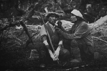 Reproducción de fotografía histórica mostrada en el Museo de Puerto Williams (Chile). En ella se aprecian dos hombres yaganes decorándose la cara con pinturas tradicionales en el siglo XIX.