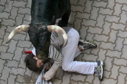 Un mozo es arrollado por un Miura en el último encierro de San Fermín.