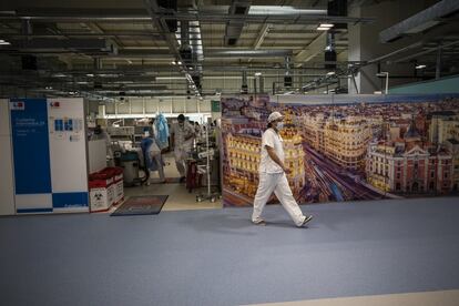 Todos los pabellones del hospital Isabel Zendal están decorados con grandes fotografías de zonas emblemáticas de Madrid. En la imagen, un médico pasa por delante de una imagen de la Gran Vía.