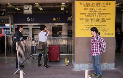 Varios pasajeros aguardan a la entrada de la estación de trenes de Shenzhen, cerca de la frontera con Hong Kong, este lunes.