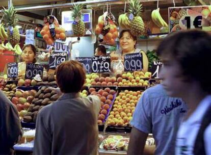 Un puesto de frutas en el mercado de La Boqueria regentado por inmigrantes, ayer.