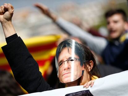 Un manifestante en Barcelona con una careta de Carles Puigdemont  / AFP