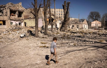 Un niño camina frente a una colegio destruido en la ciudad de Yitómir, en el noroeste de Ucrania. Más de la mitad de los menores del país han tenido que dejar sus casas para huir de los combates durante la invasión del Ejército ruso, que hoy cumple un mes, ha señalado Unicef.