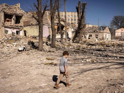 Un niño camina frente a una colegio destruido en la ciudad de Yitómir, en el noroeste de Ucrania.