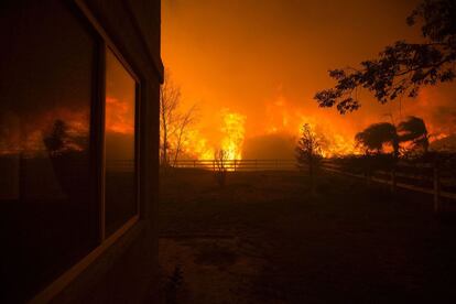 El fuego rodea una casa en Santa Clarita, California, el 23 de julio de 2016.