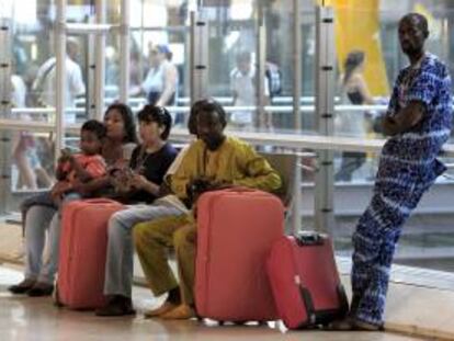 Varias personas, antes de facturar en la T4 de Madrid-Barajas para iniciar sus vacaciones.