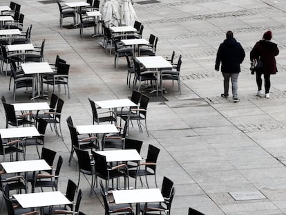 Dos personas caminan por la Plaza del Castillo de Pamplona.