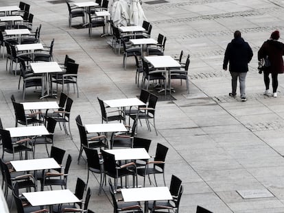 Dos personas caminan por la Plaza del Castillo, en Pamplona, al lado de mesas de las terrazas vacías, el 22 de octubre.