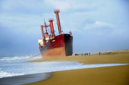 Miembros del equipo de rescate llegan al carguero 'TK Bremen', que ha encallado en la playa de Erdeven (Francia)