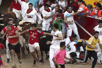 A pile of runners on the ground as the animals enter the Pamplona bullring.