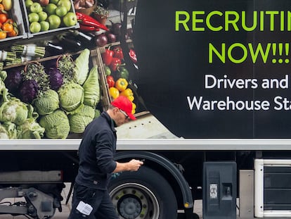 Un trabajador pasa por delante de un camión con un anuncio de contratación, el pasado miércoles en Londres.