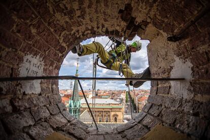 Así se ve la ciudad de Praga desde el hueco que deja el reloj de la torre de la Iglesia de Santa Ludmila, tras ser retirado para trabajos de mantenimiento. La compañía familiar L. Hainz es la encargada de poner a punto uno de los iconos de la ciudad de las 100 torres.